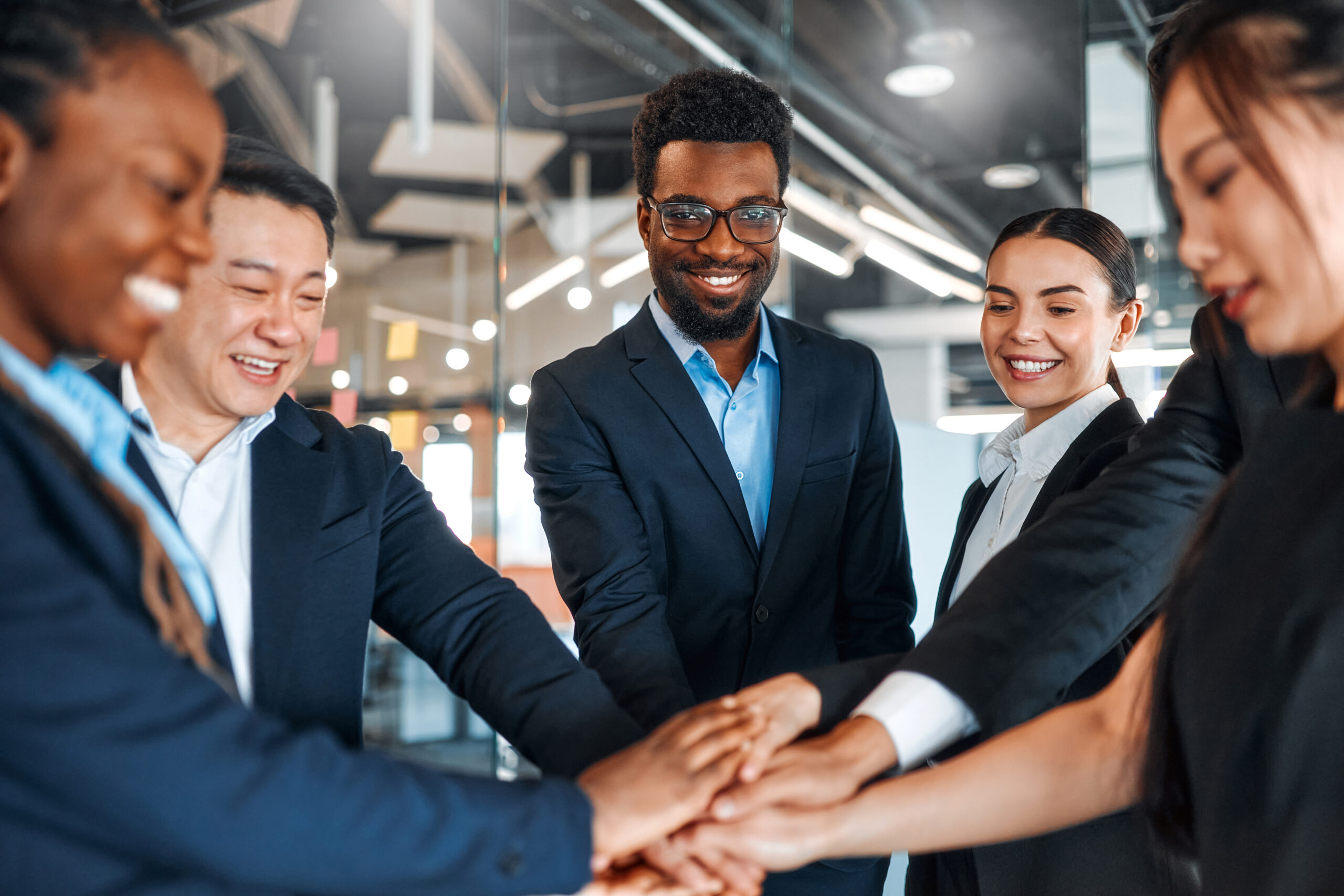 Professionals stacking their hands during a meeting show a growing business partnership.