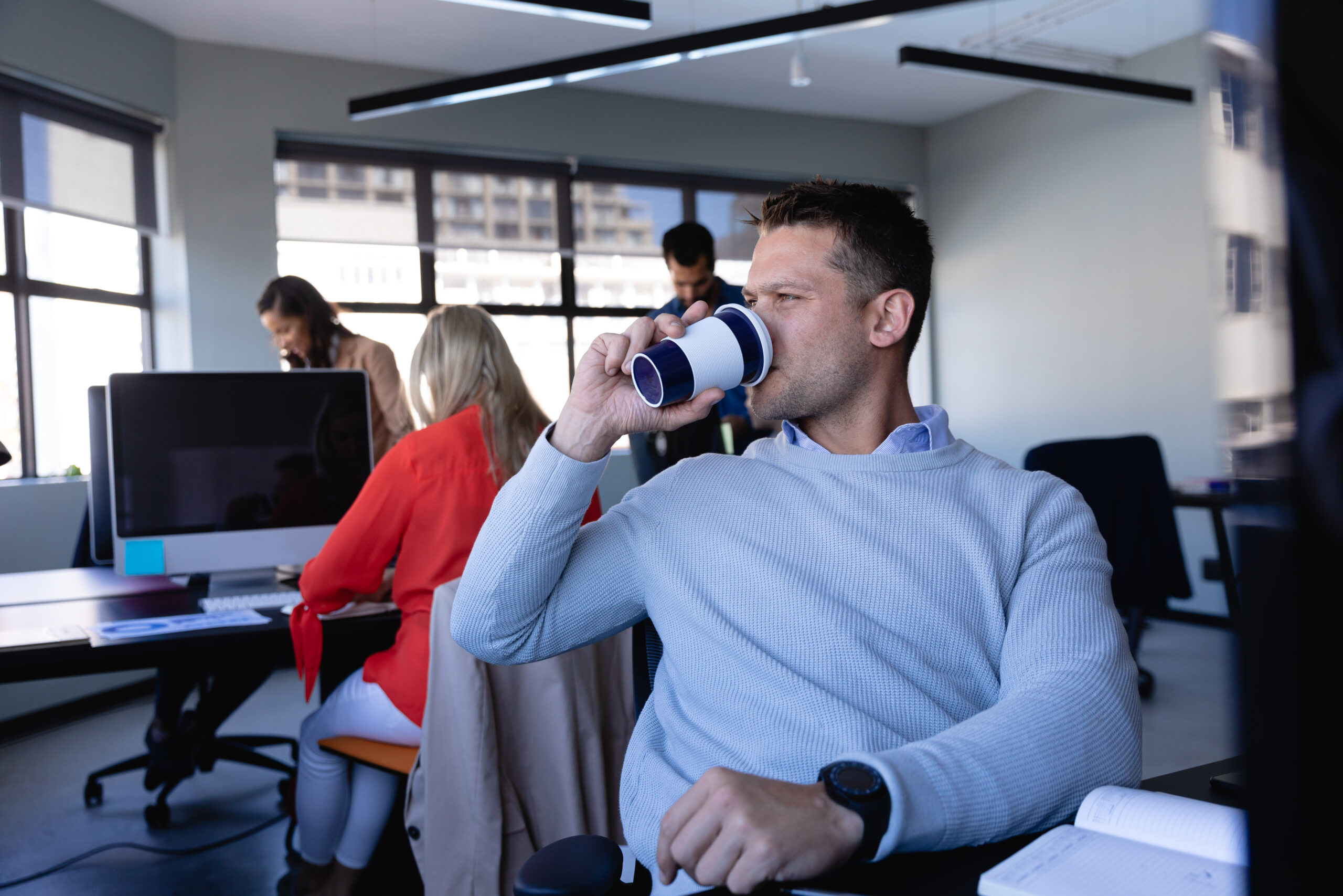 A brand ambassador drinking coffee in the office.
